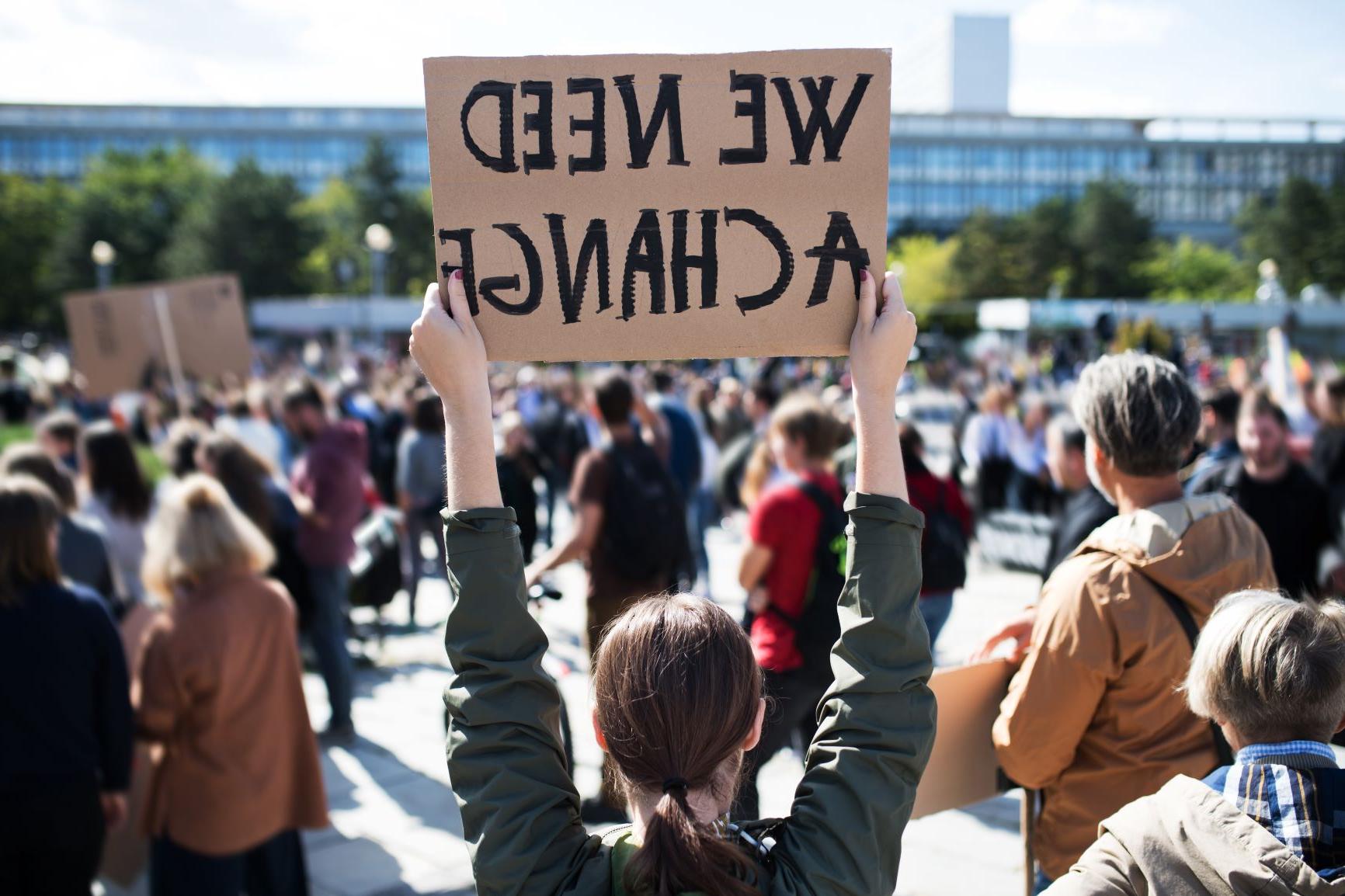 抗议标语上写着“我们需要改变”."