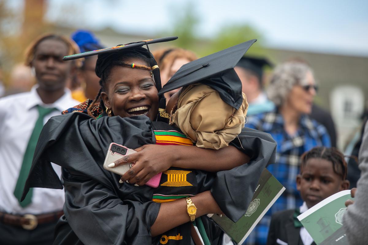 Two graduate students hugging each other after Commencement