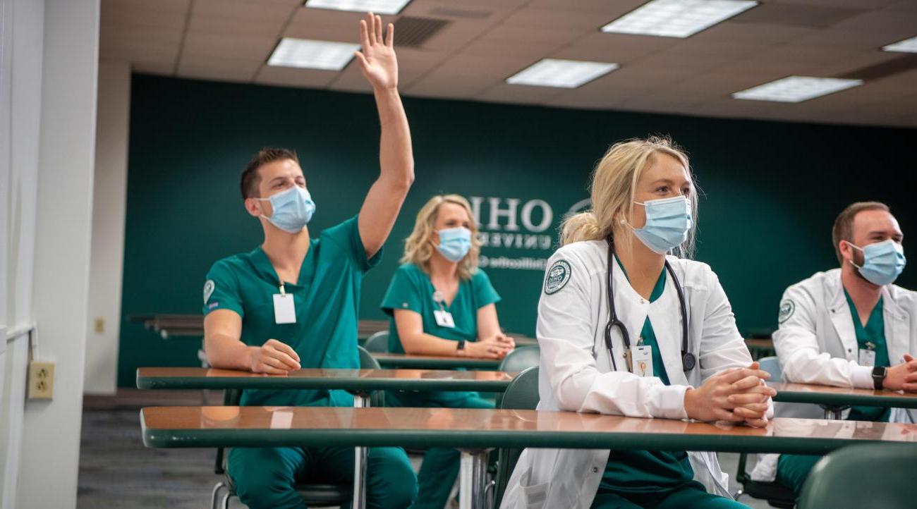 一群学生坐在护理课上，一个学生举手